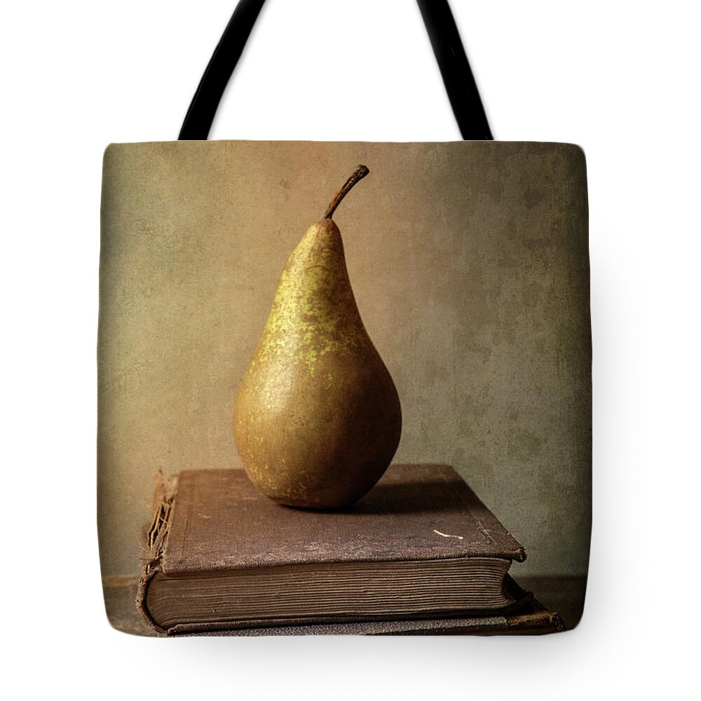 Book Tote Bag featuring the photograph Still life with old books and fresh pear by Jaroslaw Blaminsky