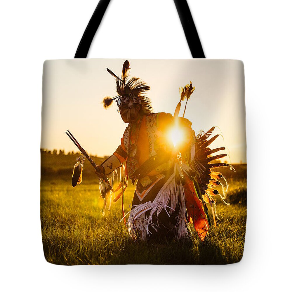 A Traditional Native American Indian Dances At Sunset At A Powwow In Montana. Tote Bag featuring the photograph Sun Dance by Todd Klassy