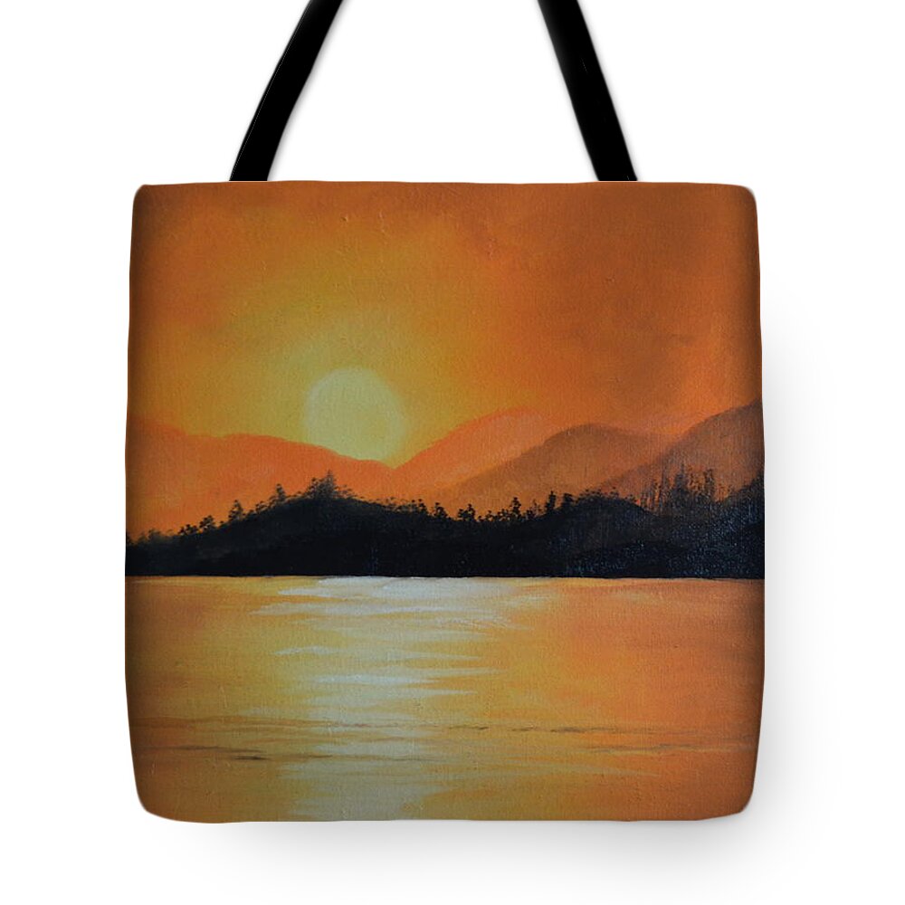 A Landscape Of Distant Mountains And A Dark Forest. The Sky Is Orange And The Lake Reflects The Color Of The Sky. Tote Bag featuring the painting Sunset by Martin Schmidt