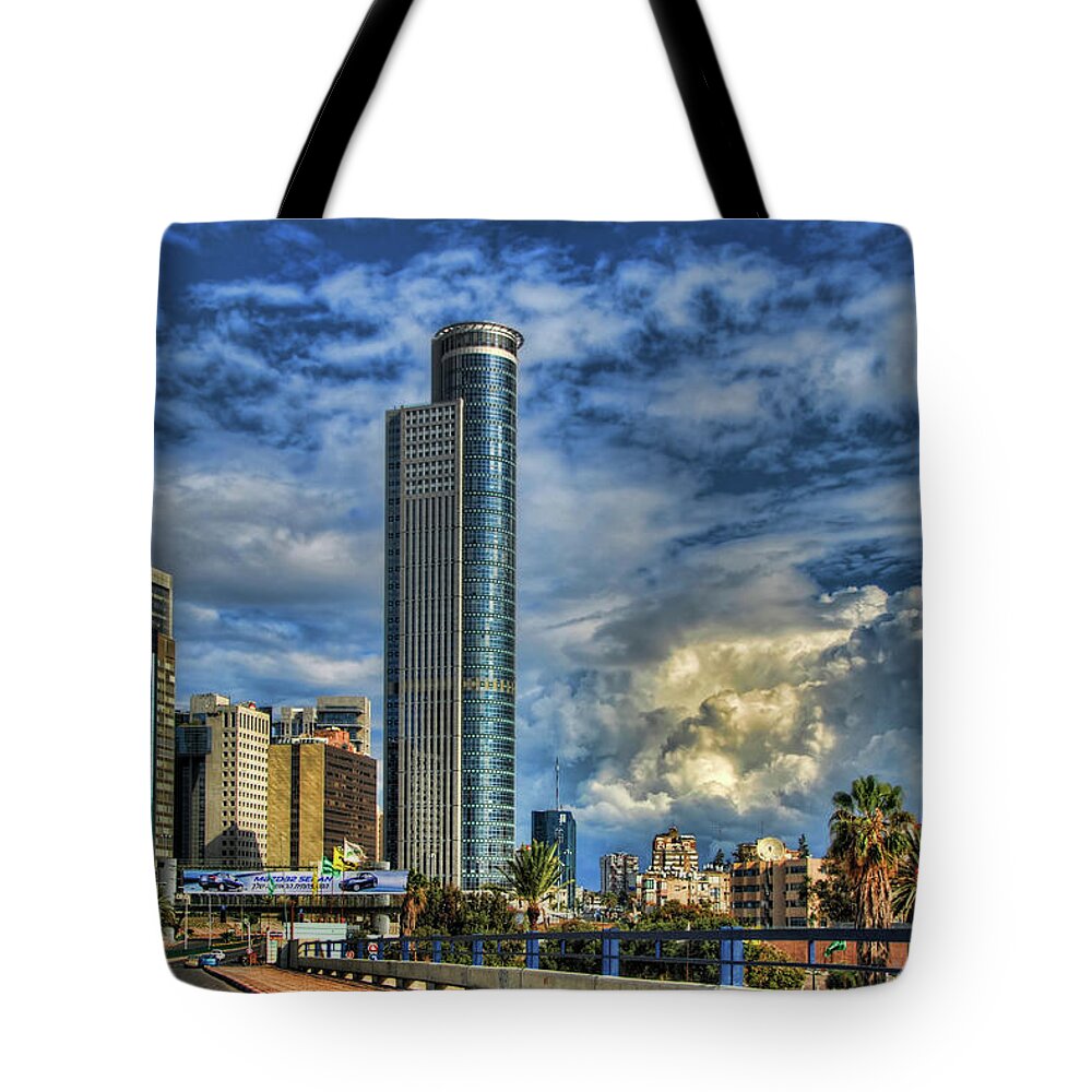 Israel Tote Bag featuring the photograph The Skyscraper And Low Clouds Dance by Ron Shoshani