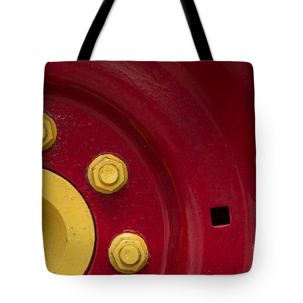 Three Tote Bag featuring the photograph Three Yellow Nuts On A Red Wheel by Wendy Wilton