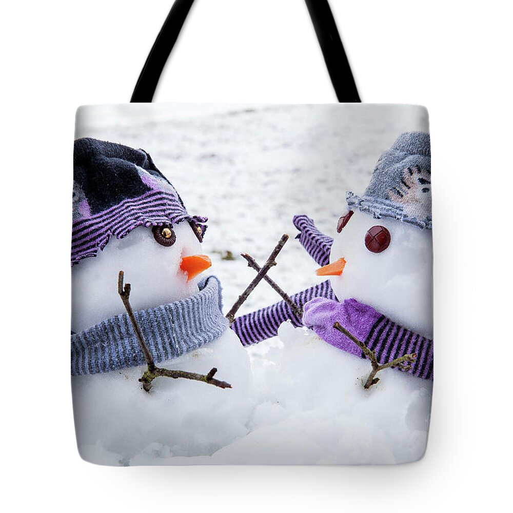 Snowmen Tote Bag featuring the photograph Two cute snowmen friends embracing by Simon Bratt