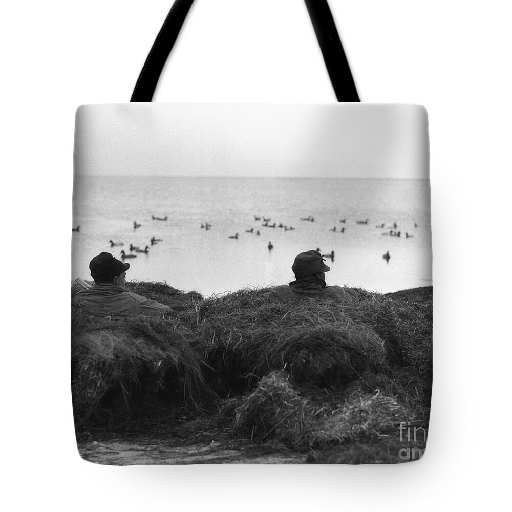1930s Tote Bag featuring the photograph Two Men Camouflaged In Duck Blind by H. Armstrong Roberts/ClassicStock