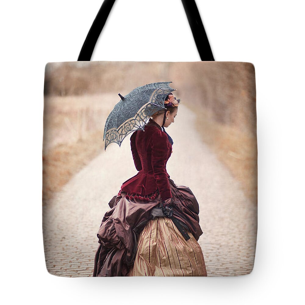 Victorian Tote Bag featuring the photograph Victorian Woman Alone On A Cobbled Path by Lee Avison