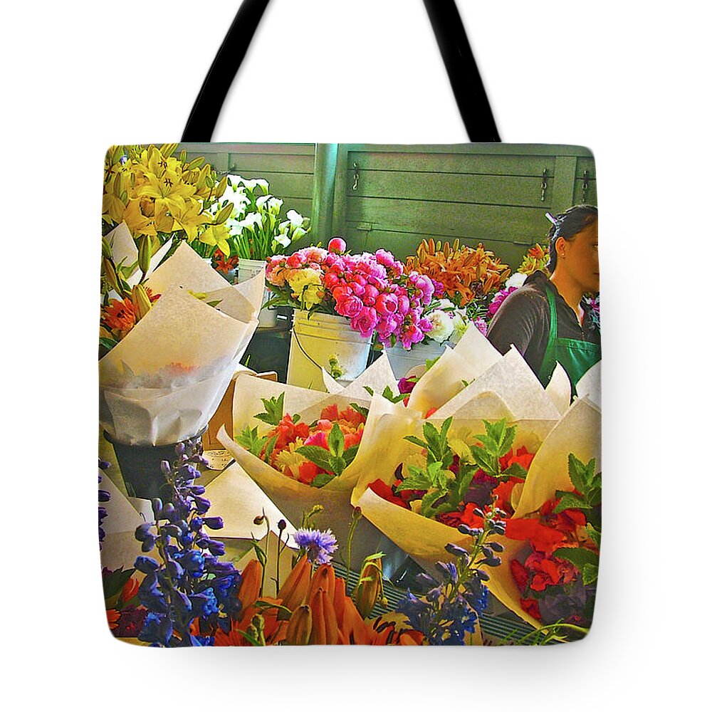 Woman Selling Flowers In Pike Street Market In Seattle Tote Bag featuring the photograph Woman Selling Flowers in Pike Street Market in Seattle, Washington by Ruth Hager