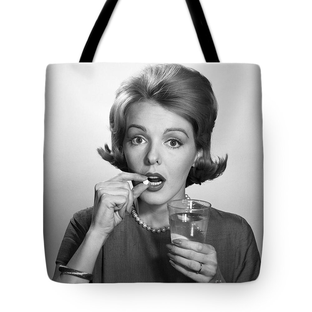 1960s Tote Bag featuring the photograph Woman Taking An Aspirin Pill by Debrocke/ClassicStock