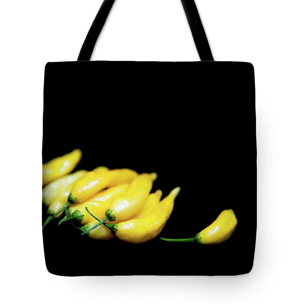 Chilies Tote Bag featuring the photograph Yellow Chillies on a Black Background by Helen Jackson