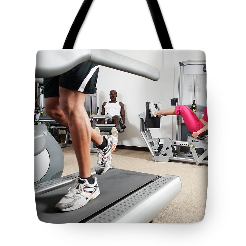 Three Quarter Length Tote Bag featuring the photograph People Exercising In Health Club #1 by Erik Isakson