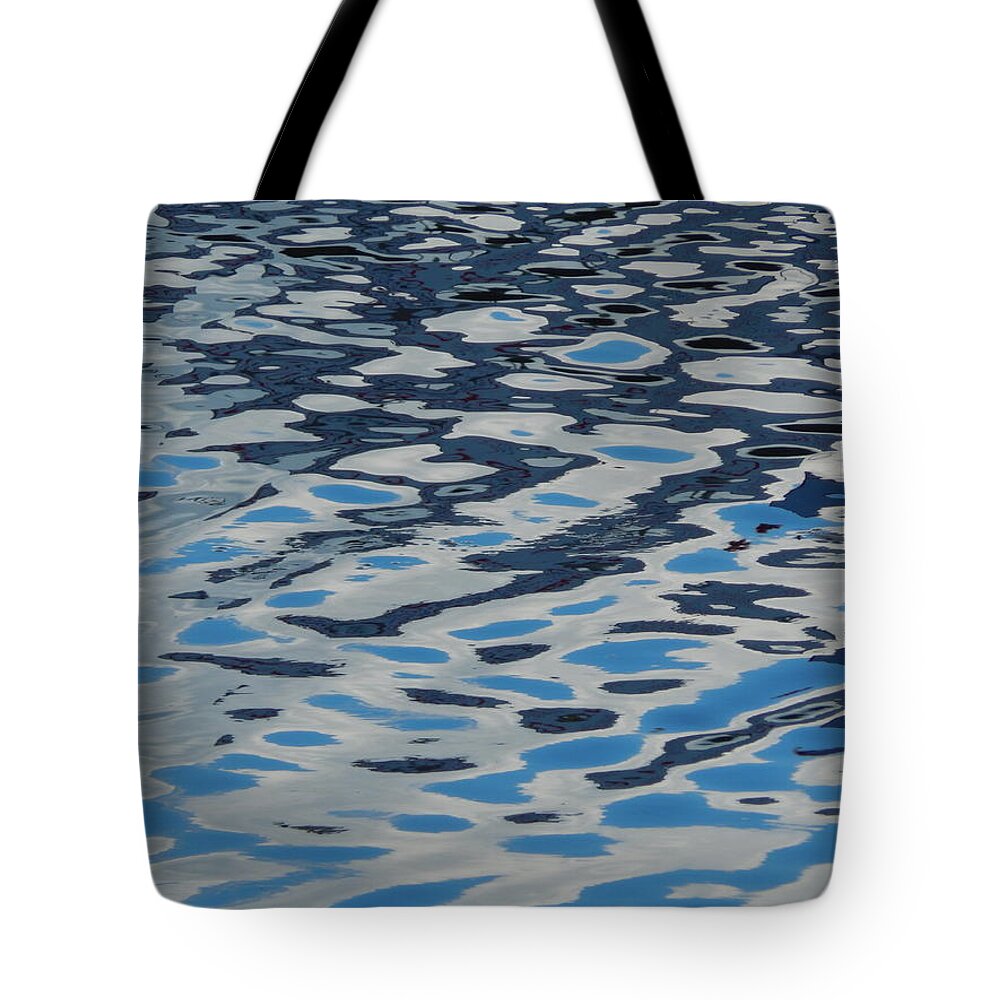 Water Tote Bag featuring the photograph Texture of water ripples on the surface of the river #1 by Oleg Prokopenko