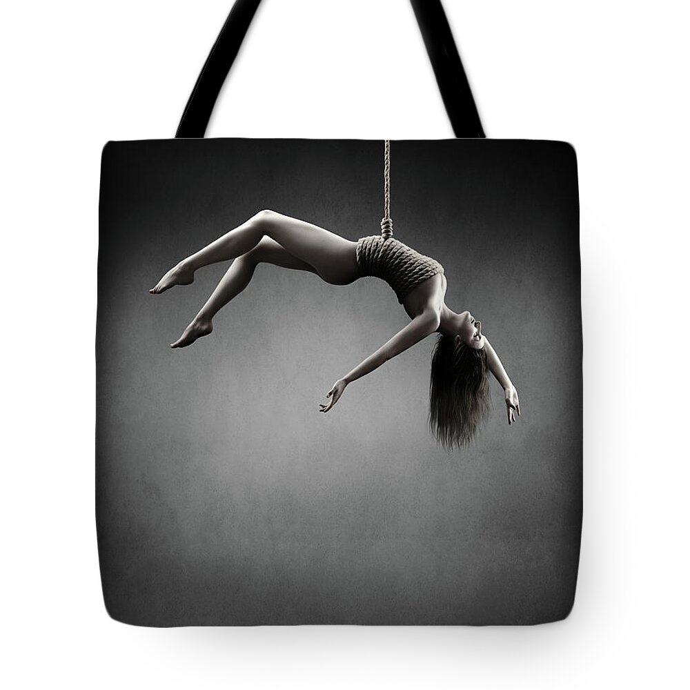 Woman Tote Bag featuring the photograph Woman hanging on a rope by Johan Swanepoel