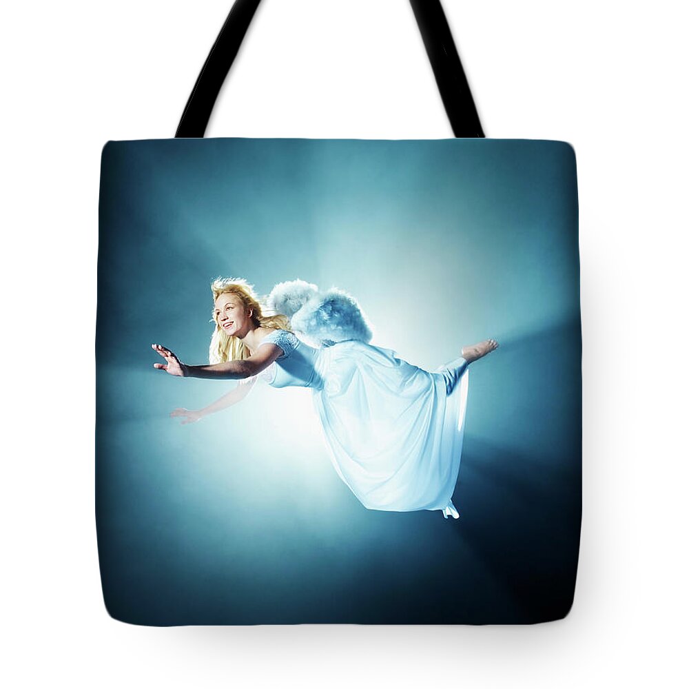 Human Arm Tote Bag featuring the photograph Young Woman In Air, Low Angle View #1 by Henrik Sorensen