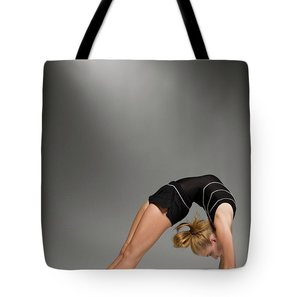 Recreational Pursuit Tote Bag featuring the photograph Female Gymnast Stretching, Studio Shot #2 by Siri Stafford