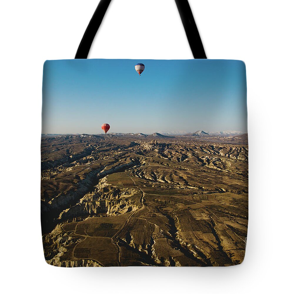 Adventure Tote Bag featuring the photograph Colorful balloons flying over mountains and with blue sky #6 by Joaquin Corbalan