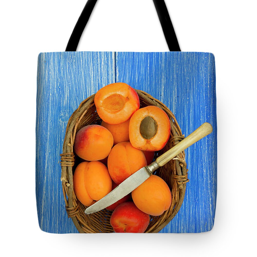 Apricot Tote Bag featuring the photograph Apricots In Basket With Knife On Table by Westend61