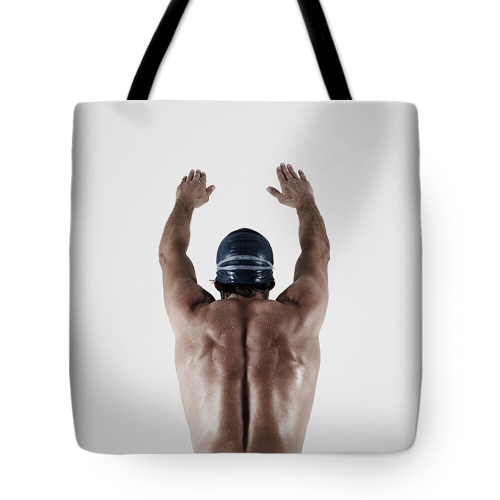 Diving Into Water Tote Bag featuring the photograph Athletic Male Swimmer In Diving Position by Mike Harrington