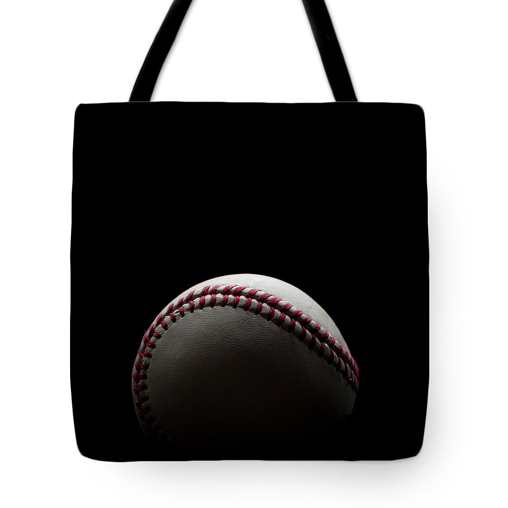 Shadow Tote Bag featuring the photograph Backlit Baseball Shot On A Black by Courtneyk