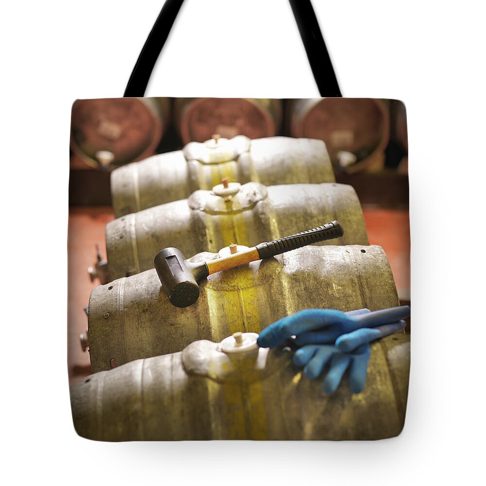 In A Row Tote Bag featuring the photograph Barrels And Hammer In Brewery by Monty Rakusen