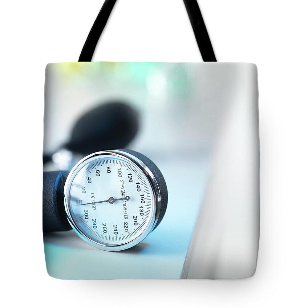 Care Tote Bag featuring the photograph Blood Pressure Gauge In Doctors Surgery by Andrew Brookes