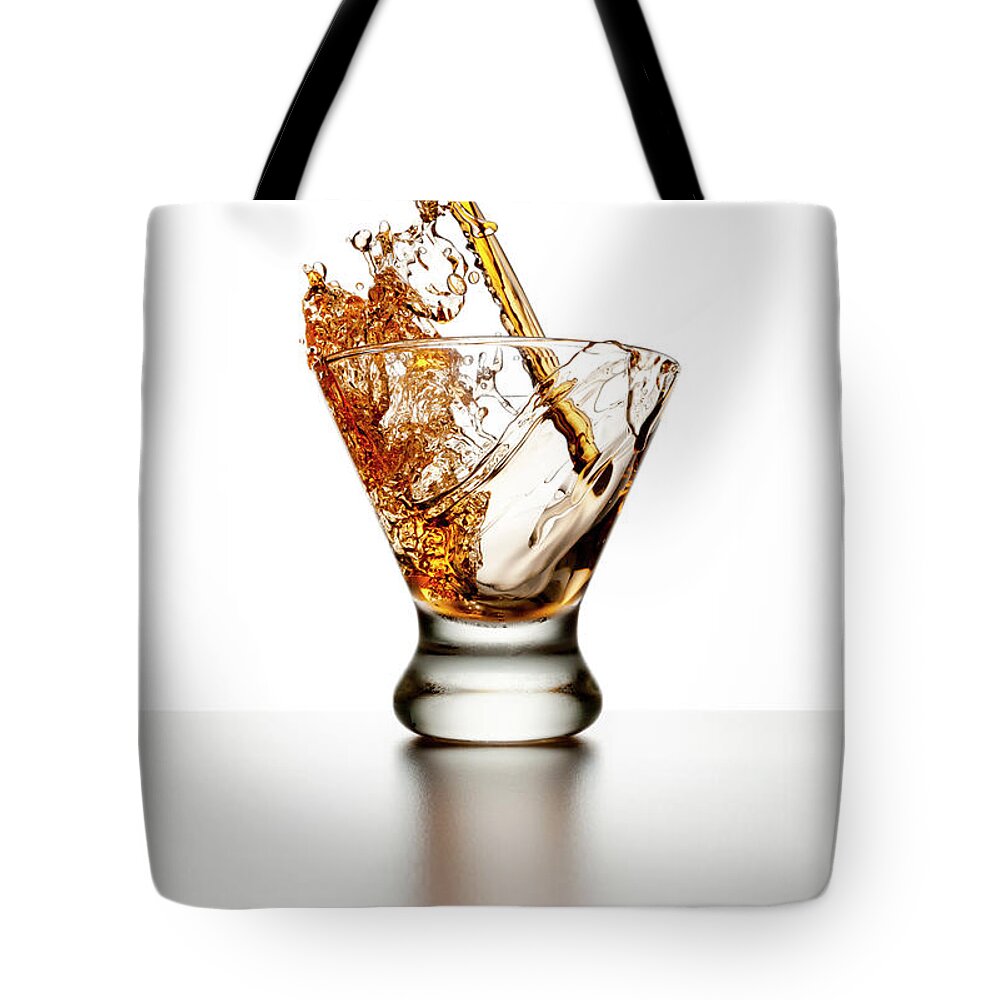 White Background Tote Bag featuring the photograph Brown Liquor Splashing Into A Glass by Chris Stein