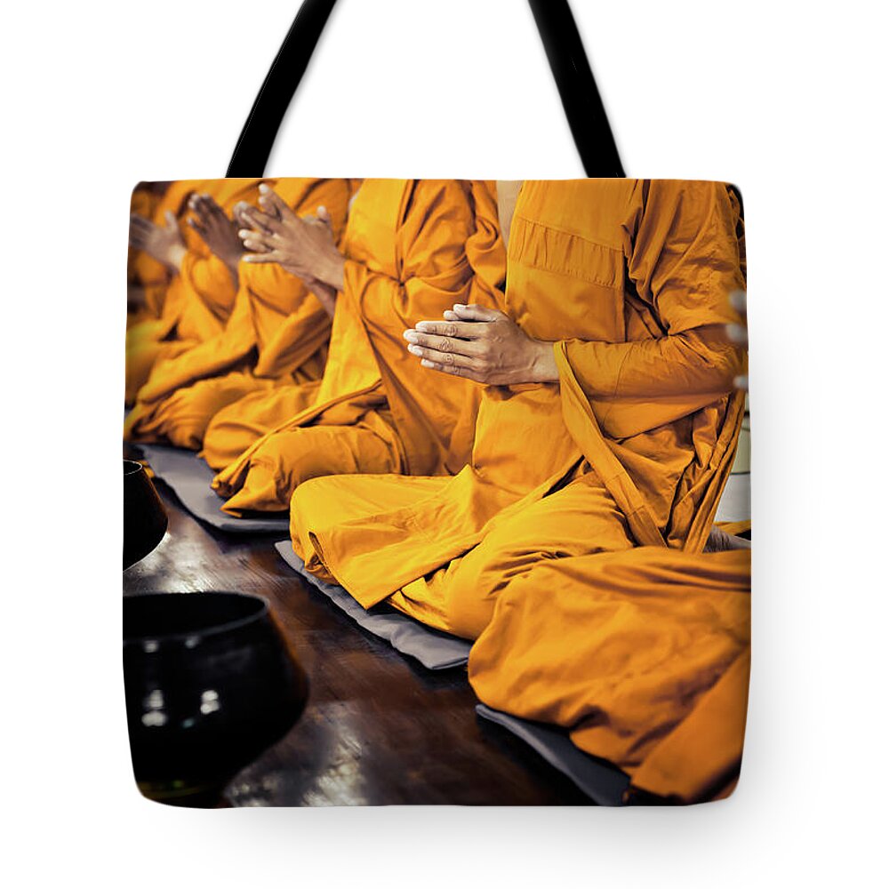 People Tote Bag featuring the photograph Buddhist Monks Praying by Fredfroese