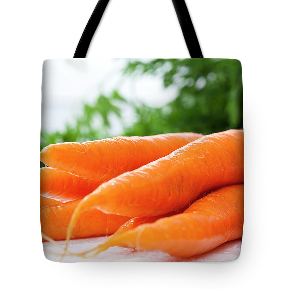 White Background Tote Bag featuring the photograph Bunch Of Fresh Carrots, Close Up by Westend61