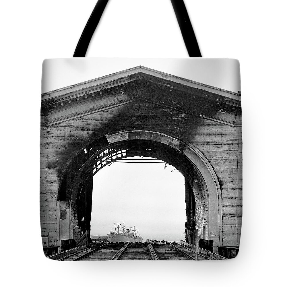 Arch Tote Bag featuring the photograph Burned Arch Over Railroad Tracks by Studio 642