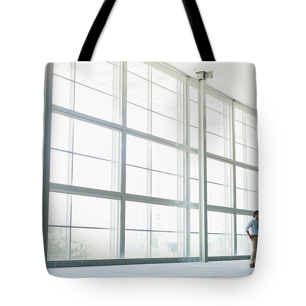 Working Tote Bag featuring the photograph Business People Talking In Lobby by Hybrid Images