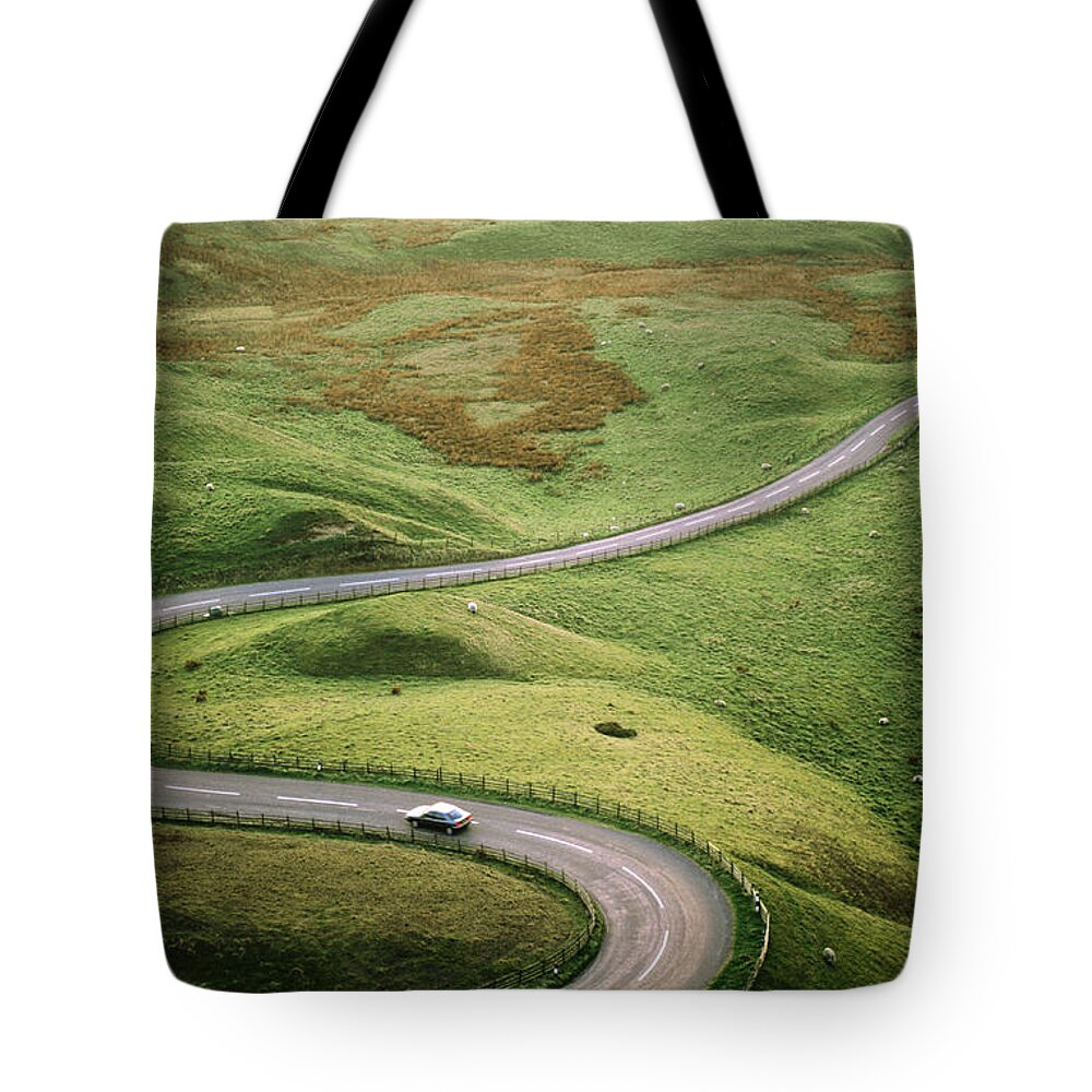 Scenics Tote Bag featuring the photograph Car Travelling Down Snaking Road by Anders Blomqvist