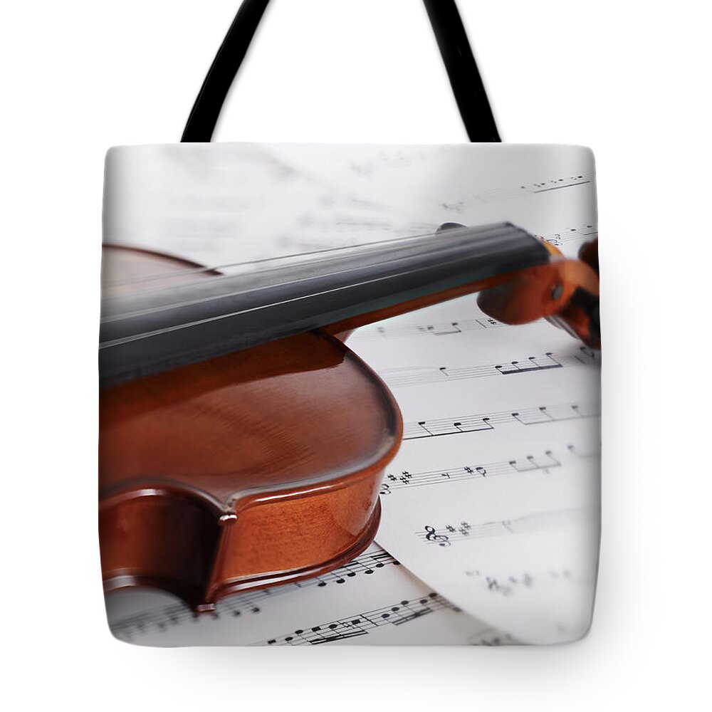 Sheet Music Tote Bag featuring the photograph Close Up Of Violin And Sheet Music by Adam Gault