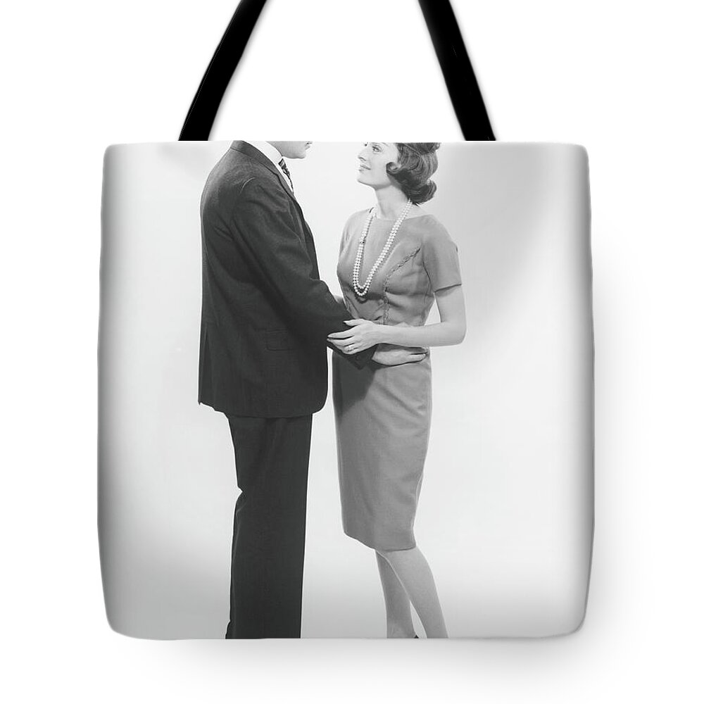 Heterosexual Couple Tote Bag featuring the photograph Couple Looking In Eyes In Studio, B&w by George Marks