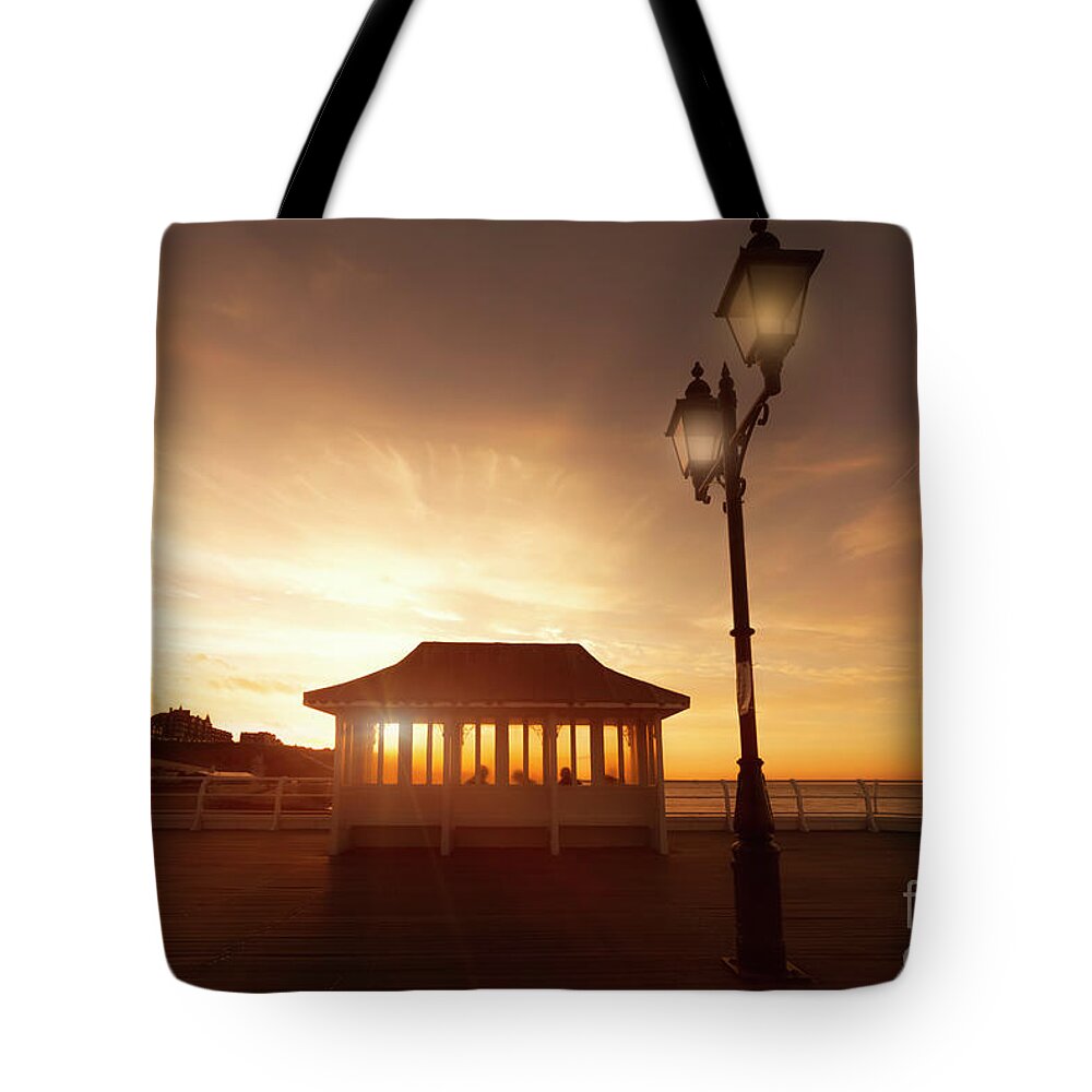 Norfolk Tote Bag featuring the photograph Cromer pier in Norfolk England shelter at sunset by Simon Bratt
