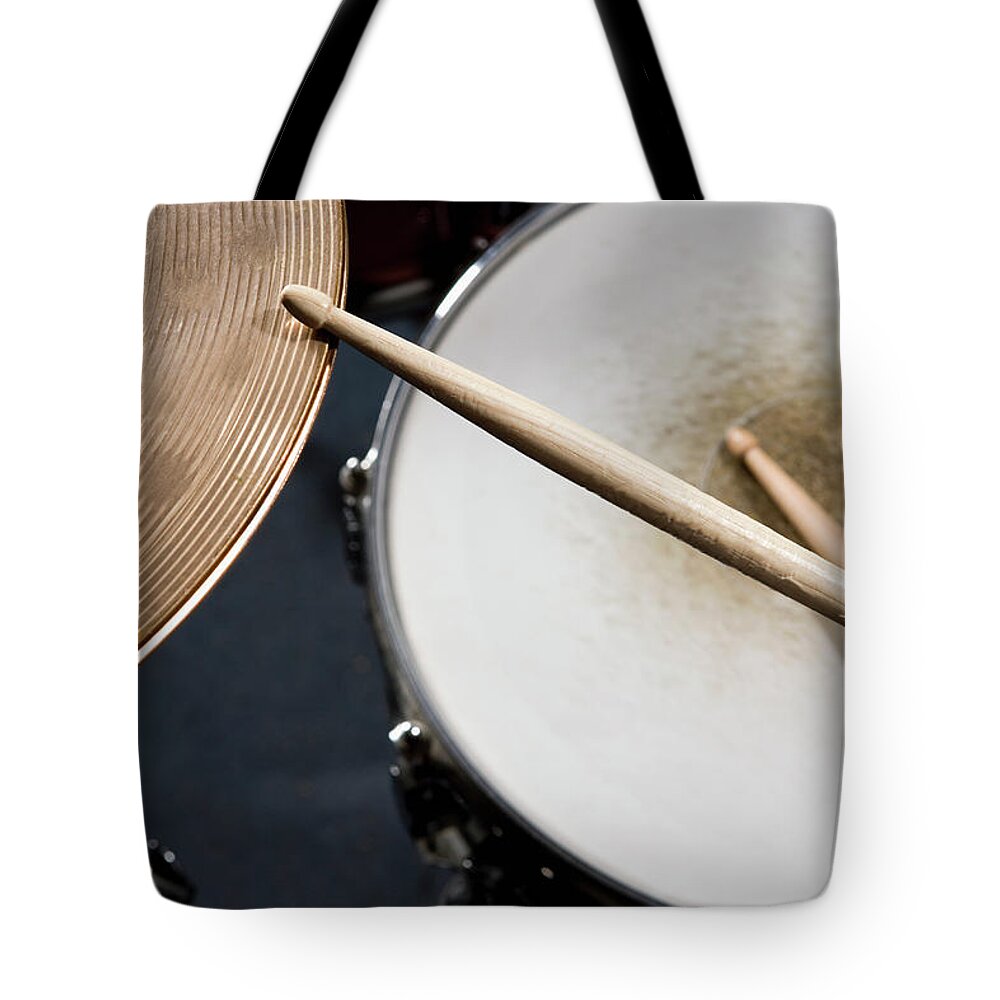 Creativity Tote Bag featuring the photograph Detail Of Drumsticks And A Drum Kit by Antenna