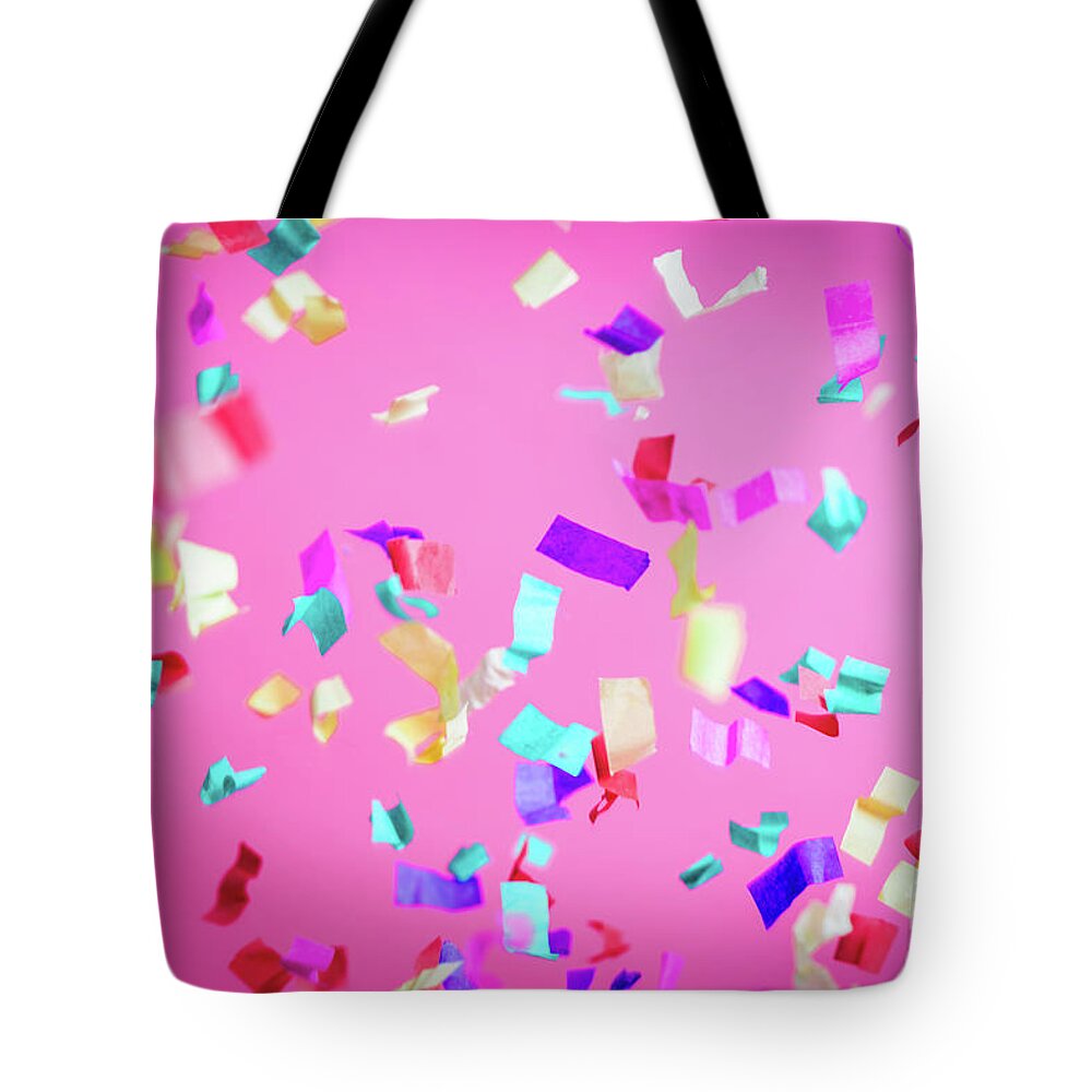 Party Tote Bag featuring the photograph Falling confetti on pink background. by Michal Bednarek