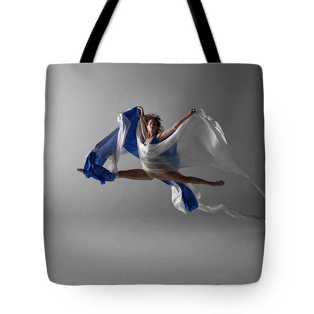 Ballet Dancer Tote Bag featuring the photograph Female Dancer Performing A Grand Jeté by Nisian Hughes