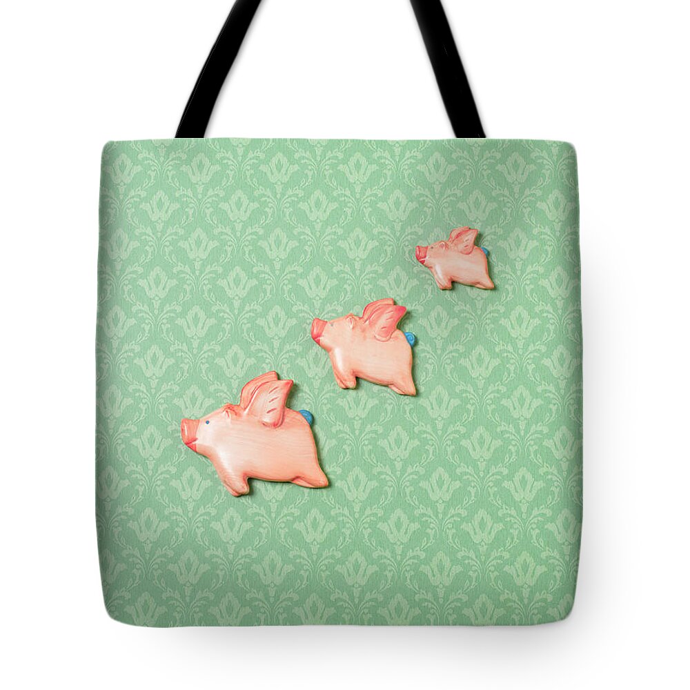 Disbelief Tote Bag featuring the photograph Flying Pig Ornaments On Wallpapered by Peter Dazeley