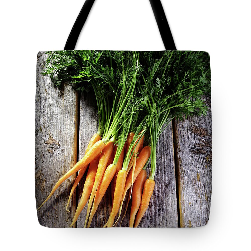 Close-up Tote Bag featuring the photograph Fresh Carrots On Rustic Wood by Jurgen Wiesler