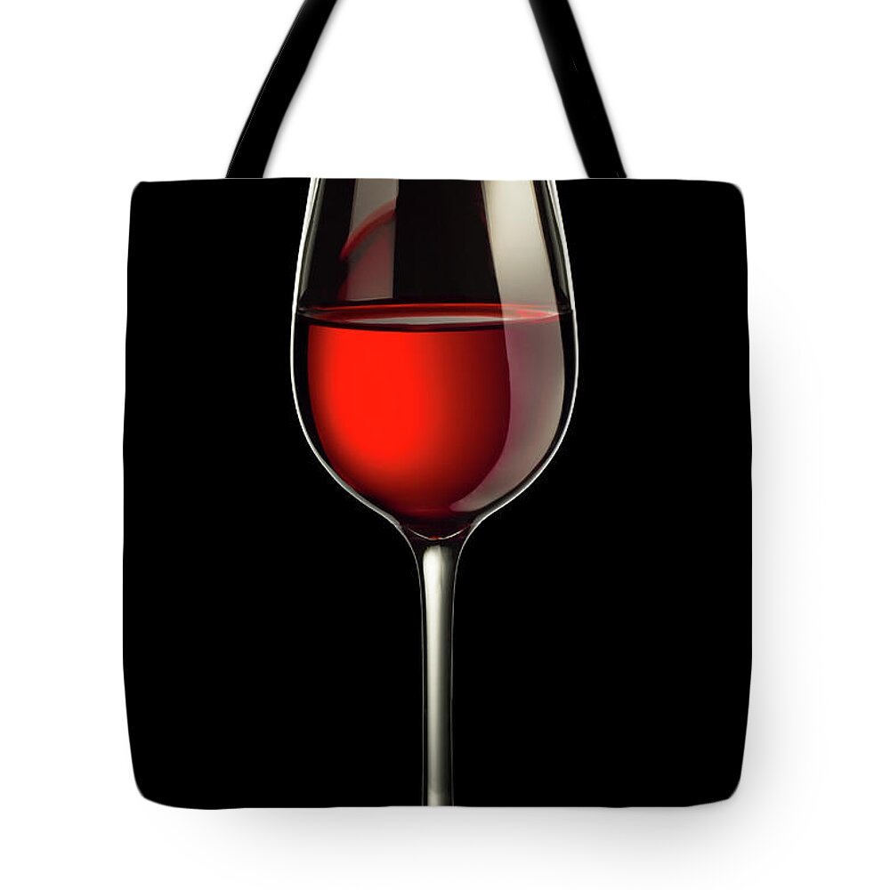 Alcohol Tote Bag featuring the photograph Glass Of Red Wine On Black by Dmax-foto