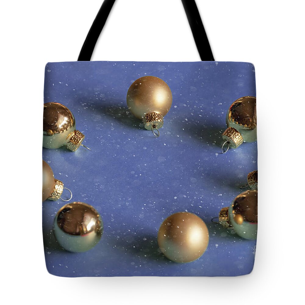 Decoration Tote Bag featuring the photograph Golden christmas balls on the snowy background by Marina Usmanskaya