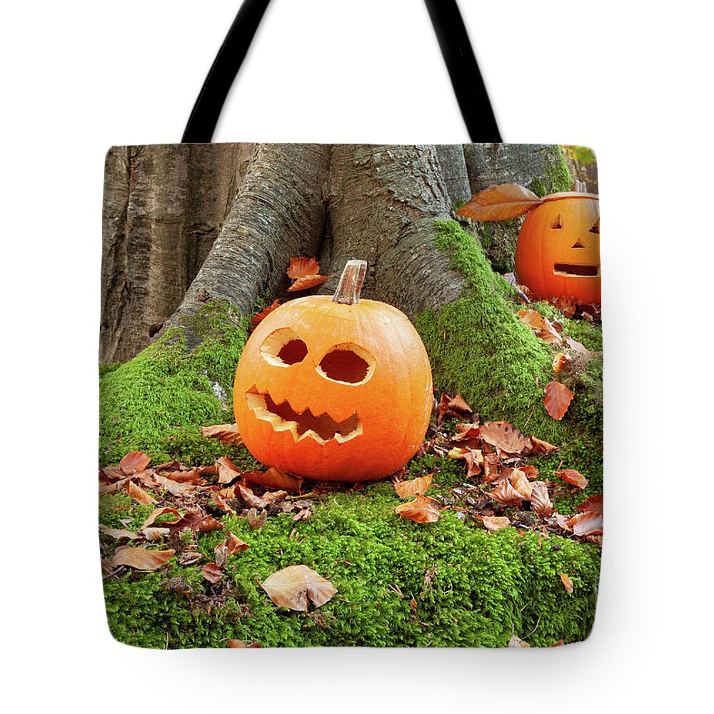 Pumpkins Tote Bag featuring the photograph Halloween scary pumpkins in the woods by Simon Bratt