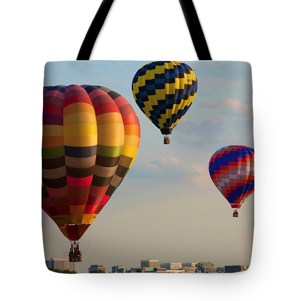Hot Air Balloons Tote Bag featuring the photograph Hot air balloons flying over the city by Tatiana Travelways