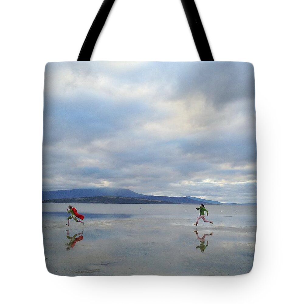 Young Men Tote Bag featuring the photograph Man Chasing Another Man Dressed As A by Jodie Griggs