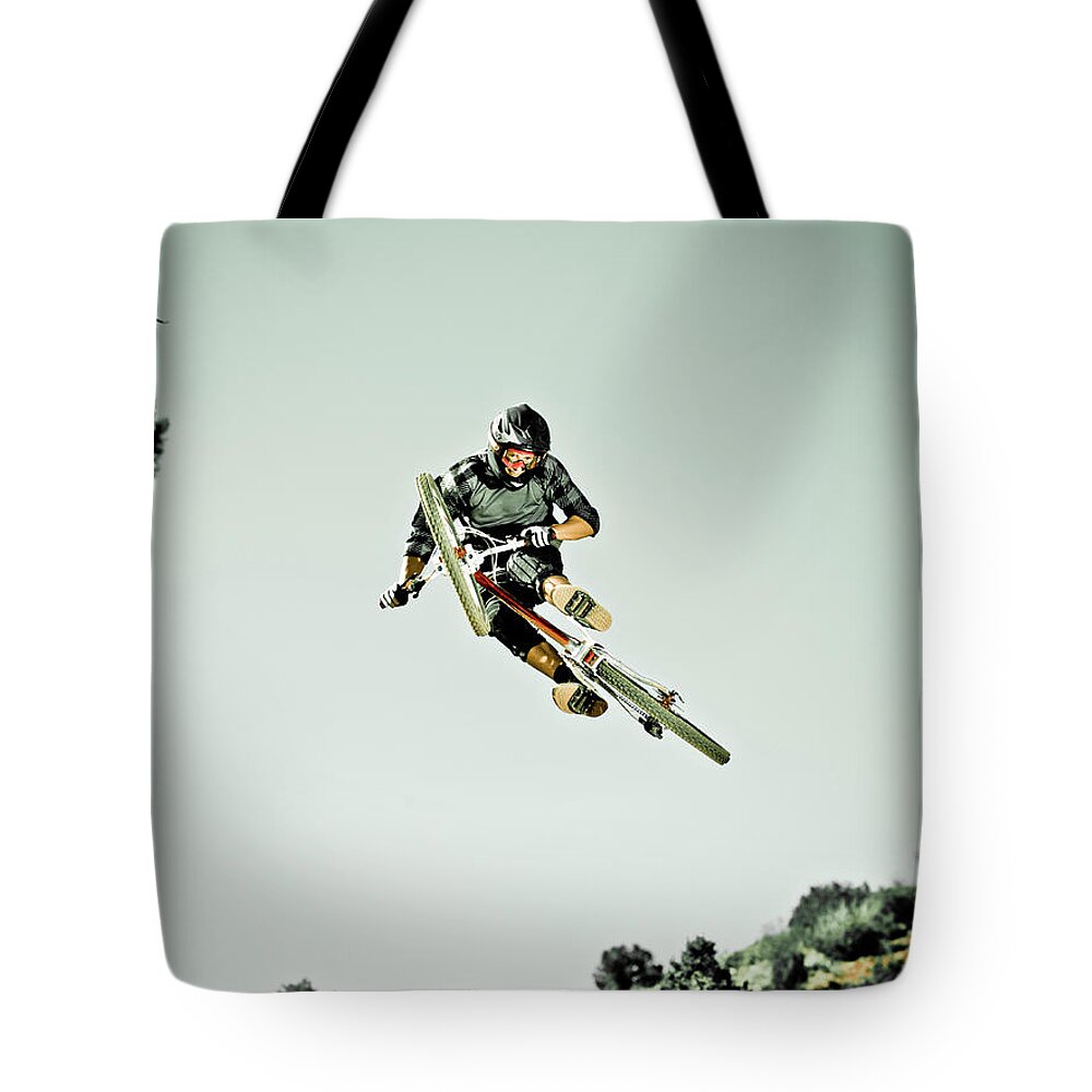Young Men Tote Bag featuring the photograph Man Jumping Mountain Bike In Mid-air by Doug Berry