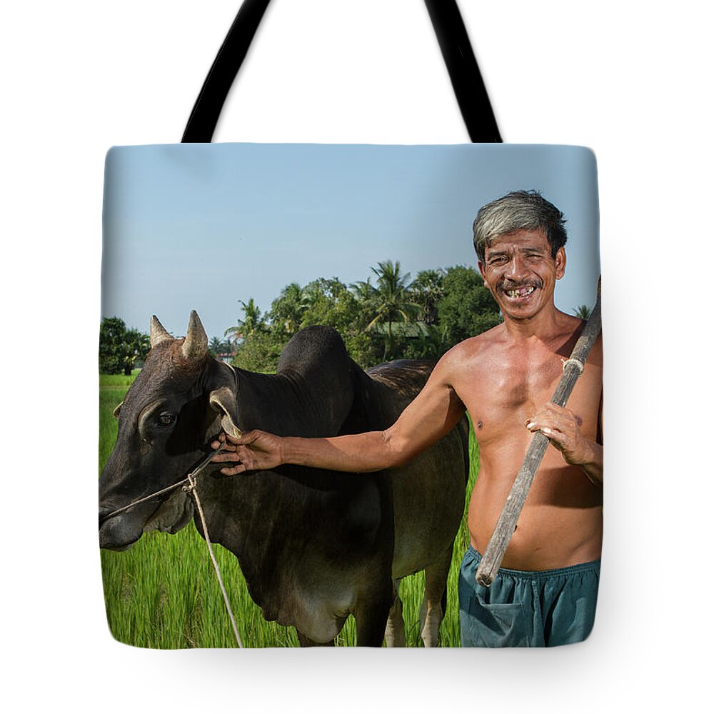 Working Tote Bag featuring the photograph Matured Asian Farmer With Cow by Joakimbkk