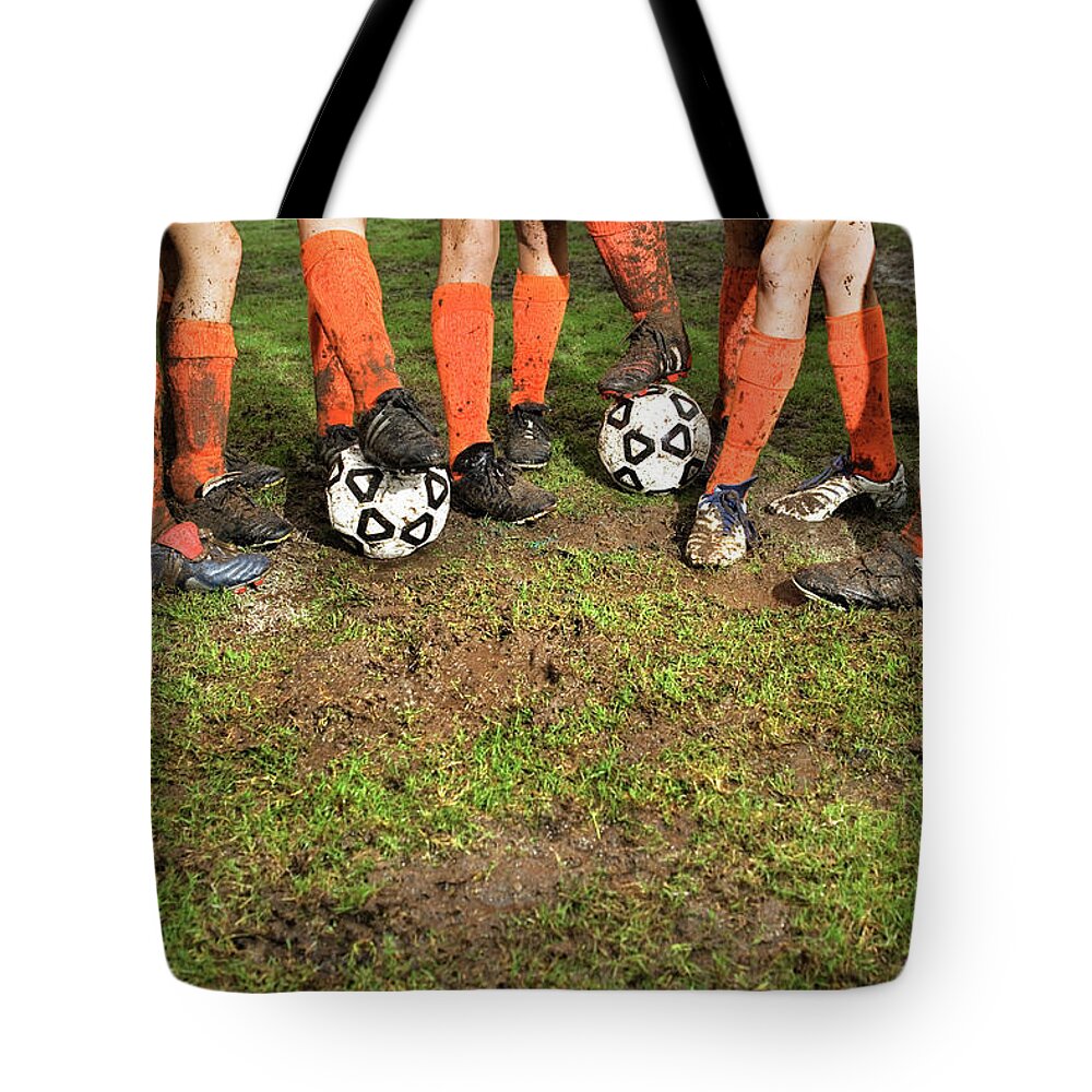 Soccer Uniform Tote Bag featuring the photograph Muddy Legs Of Soccer Players by Jupiterimages