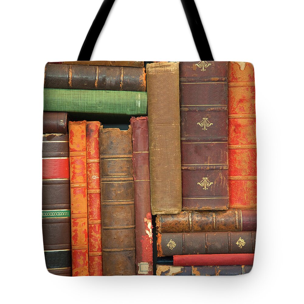 Education Tote Bag featuring the photograph Old Books Stacked Oddly On A Shelf by Grant Faint