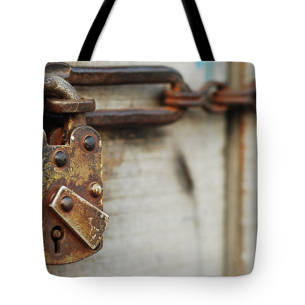 Security Tote Bag featuring the photograph Old Lock On Wooden Door by Raja Islam