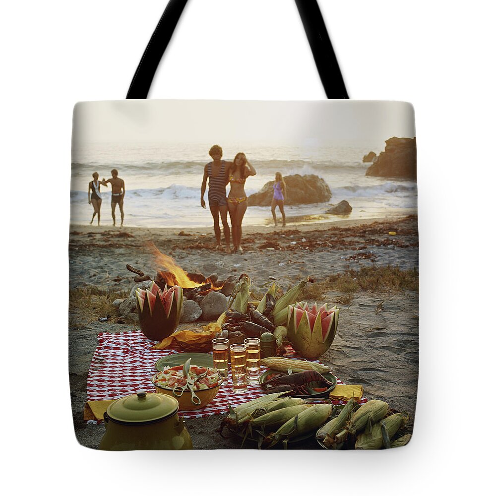 Young Men Tote Bag featuring the photograph Picnic On Beach by Tom Kelley Archive