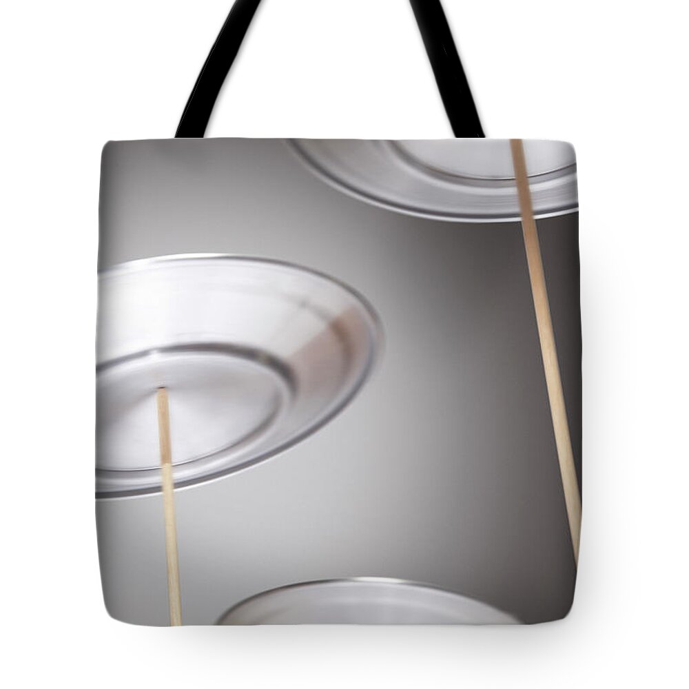 Expertise Tote Bag featuring the photograph Plates Spinning On Sticks by Moodboard