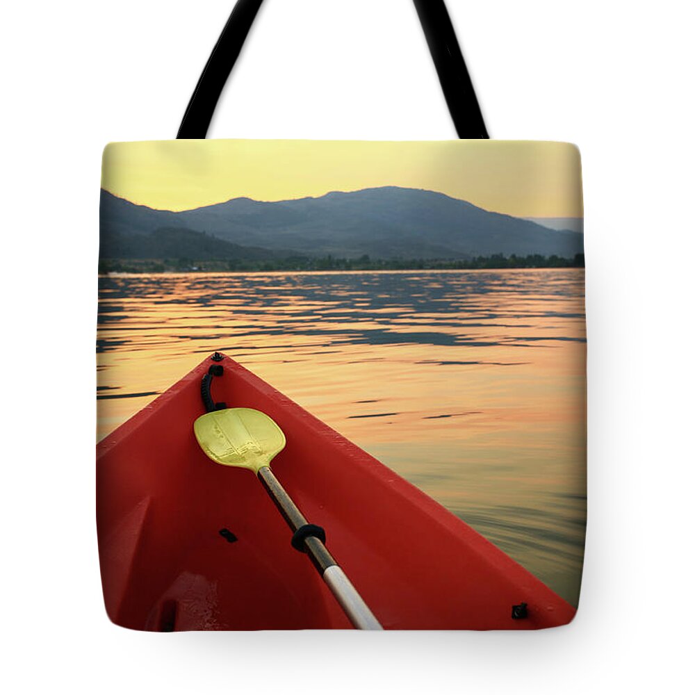 Recreational Pursuit Tote Bag featuring the photograph Red Canoe On A Beautiful Mountain Lake by Imaginegolf