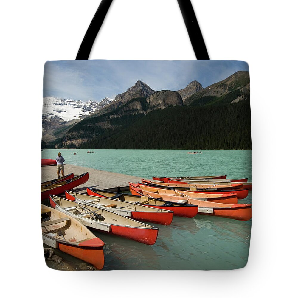 Tranquility Tote Bag featuring the photograph Red Kayak Boats On Lake Louise by © Francois Marclay